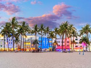 Palmen und bunte Liegen am South Beach bei Sonnenuntergang | MSC Cruises
