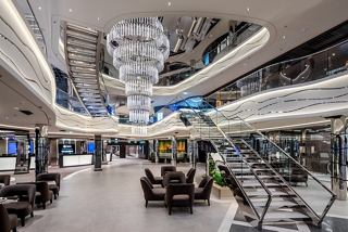 Contemporary public area featuring an elegant chandelier and stairs | MSC Cruises