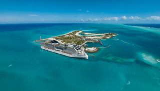 A ship sails through crystal-clear waters near a tropical island | MSC Cruises