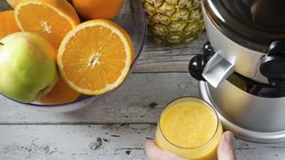Freshly cut oranges and green apples prepared for juicing, with a juicer in the background | MSC Cruises