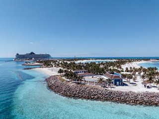 Vista aérea de Ocean Cay MSC Marine Reserve con un barco y una playa contra un fondo de océano azul | MSC Cruceros