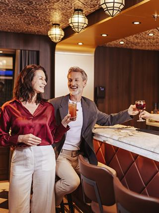 A couple enjoys cocktails in a cozy bar on a cruise ship | MSC Cruises