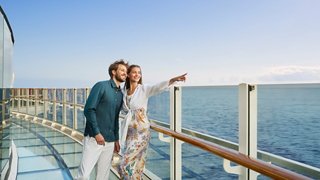 Ein Paar genießt den Meerblick von der Balkon eines Kreuzfahrtschiffes | MSC Cruises
