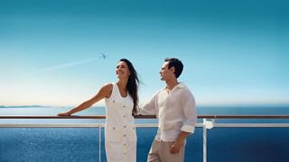 A young couple enjoys the beautiful view from a cruise ship deck | MSC Cruises