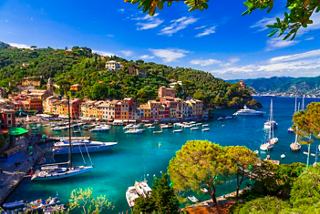 Vista aérea de un pueblo costero con casas coloridas y barcos en el mar en Portofino, Italia | MSC Cruises