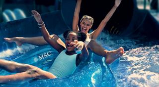 Children are enjoying the water park, playing and swimming in the blue water | MSC Cruises