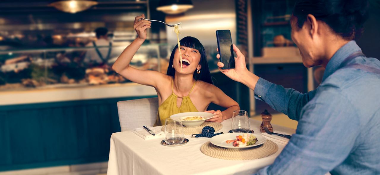 Zwei Freunde genießen Essen und Lachen in einem Restaurant | MSC Cruises