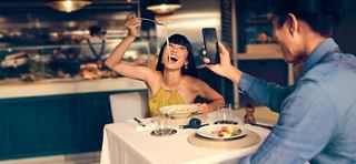 Two friends enjoy food and laughter together at a restaurant | MSC Cruises