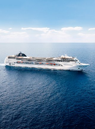 Die MSC Lirica segelt elegant über die ruhigen Gewässer unter einem hellen Himmel | MSC Cruises
