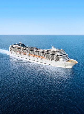 Ein atemberaubendes Kreuzfahrtschiff segelt elegant durch ruhige Gewässer unter einem klaren blauen Himmel | MSC Cruises