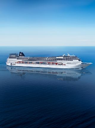 Un majestuoso barco de crucero se desliza graciosamente sobre aguas azules tranquilas bajo un cielo despejado | MSC Cruceros