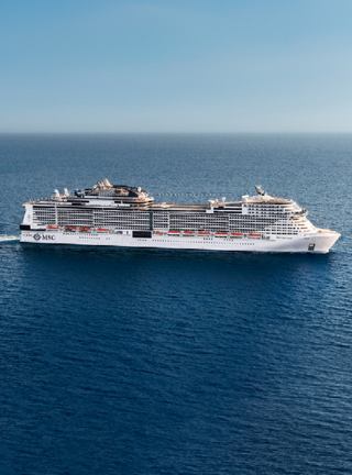 A majestic cruise ship gliding through calm blue waters under a clear sky | MSC Cruises