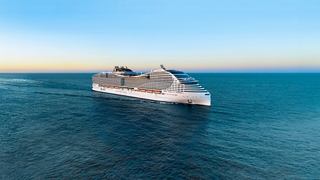 A stunning cruise ship sailing on calm waters under a clear blue sky | MSC Cruises