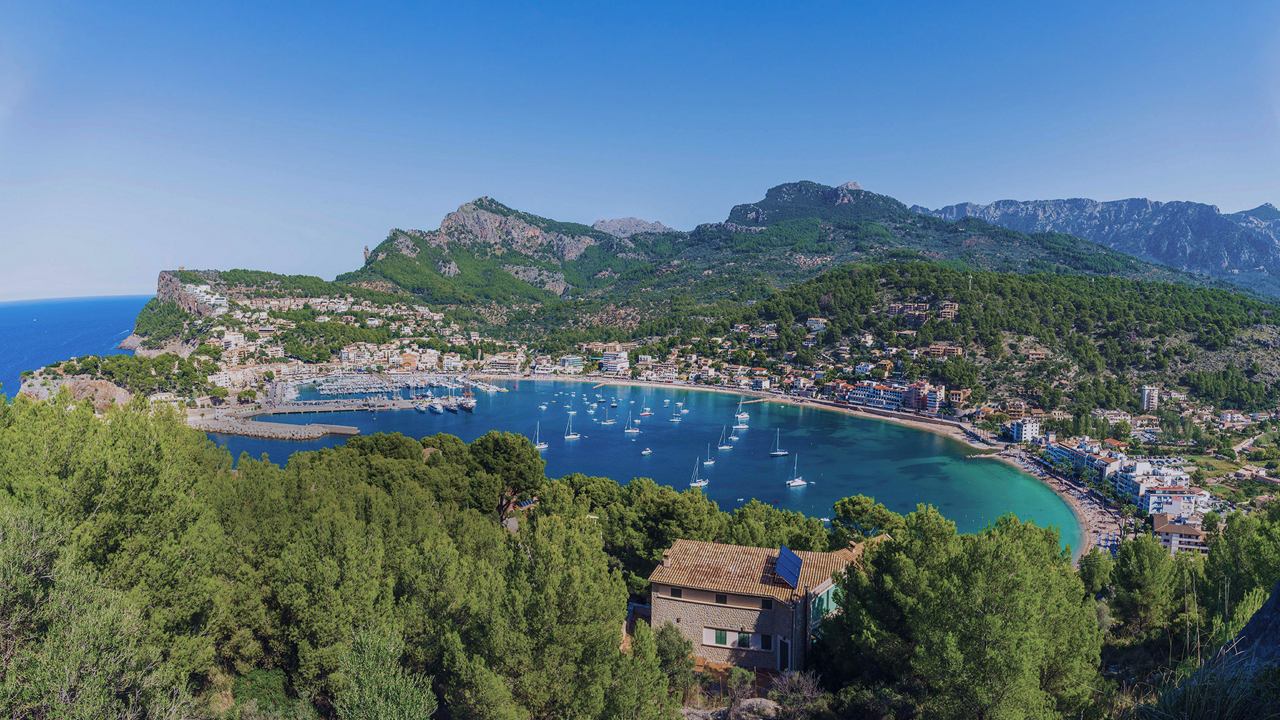 Tranquil bay surrounded by greenery and mountains in the background | MSC Cruises