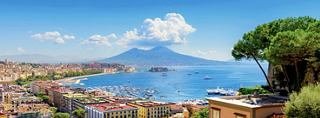 A panoramic view of Naples overlooking the Gulf and Mount Vesuvius with boats and buildings in the foreground | MSC Cruises