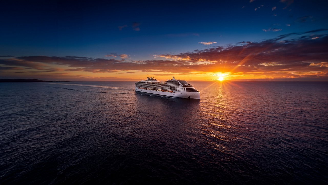 Silhouette of a ship at sea at sunset with colorful sky | MSC Cruises