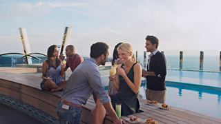 A group of friends enjoys cocktails by the pool on a cruise ship | MSC Cruises