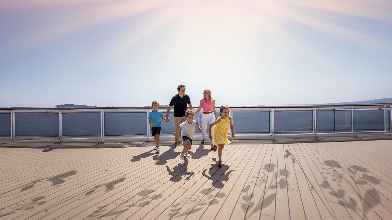 Four people enjoy the sun on the beach, smiling and playing in the sand | MSC Cruises