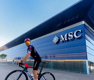 A cyclist poses confidently outside the MSC headquarters, showcasing a spirit of adventure and exploration | MSC Cruises