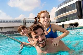 A joyful family enjoying a sunny day by the pool, creating unforgettable summer memories together | MSC Cruises
