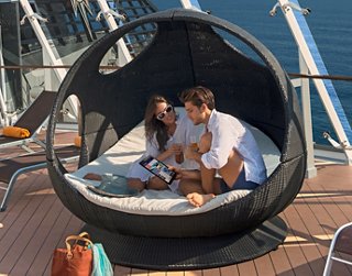 A couple relaxes together in a stylish hanging pod on a cruise ship, enjoying their time at sea | MSC Cruises