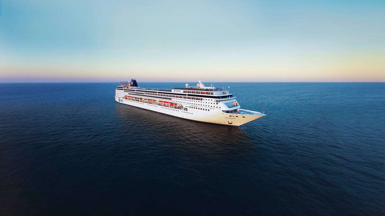 A stunning view of the MSC Armonia cruising through calm waters during sunset | MSC Cruises