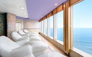 Ein ruhiger Entspannungsbereich mit bequemen Liegen und großen Fenstern, die einen atemberaubenden Meerblick bieten | MSC Cruises