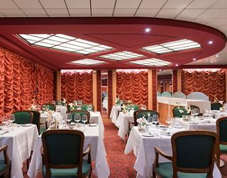 Gemütliches Restaurant mit eleganten Tischen, die für das Abendessen gedeckt sind | MSC Cruises