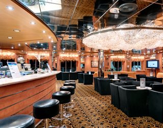 Ein moderner Barbereich mit bequemen Sitzgelegenheiten und warmem Licht | MSC Cruises