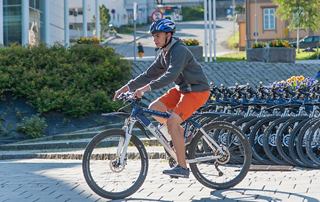 Una persona in abbigliamento sportivo pedala lungo una strada tranquilla circondata da verde | MSC Crociere