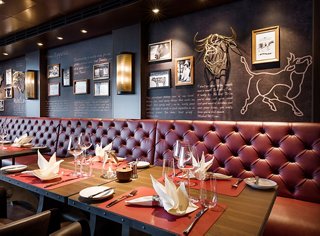 A cozy restaurant space with red leather seating and stylish decor | MSC Cruises