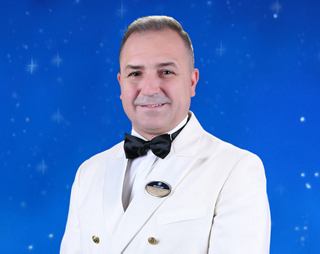 Captain Di Mauro standing in uniform beside navigational equipment | MSC Cruises