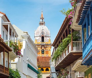 Une rue animée à Carthagène, mettant en valeur l'architecture historique et une horloge remarquable sous un ciel bleu clair | MSC Cruises
