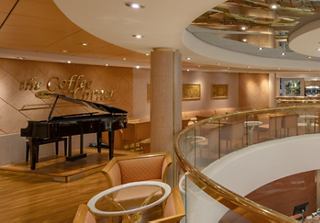 A cozy corner with a piano and comfortable seating in an elegant setting | MSC Cruises