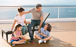 A family enjoys playful moments together on deck, with the sea in the background, creating joyful memories | MSC Cruises