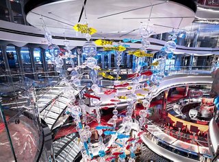 Amplio atrio en un barco de crucero con asientos coloridos y elementos de diseño | MSC Cruceros