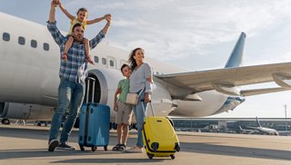 A joyful family celebrates their arrival at the airport with luggage, ready for an exciting travel adventure | MSC Cruises