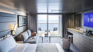 Stylish cabin with large windows, offering a cozy atmosphere and stunning views | MSC Cruises