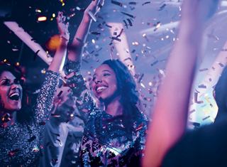 Junge Menschen genießen eine lebhafte Party mit bunten Lichtern und Konfetti | MSC Cruises