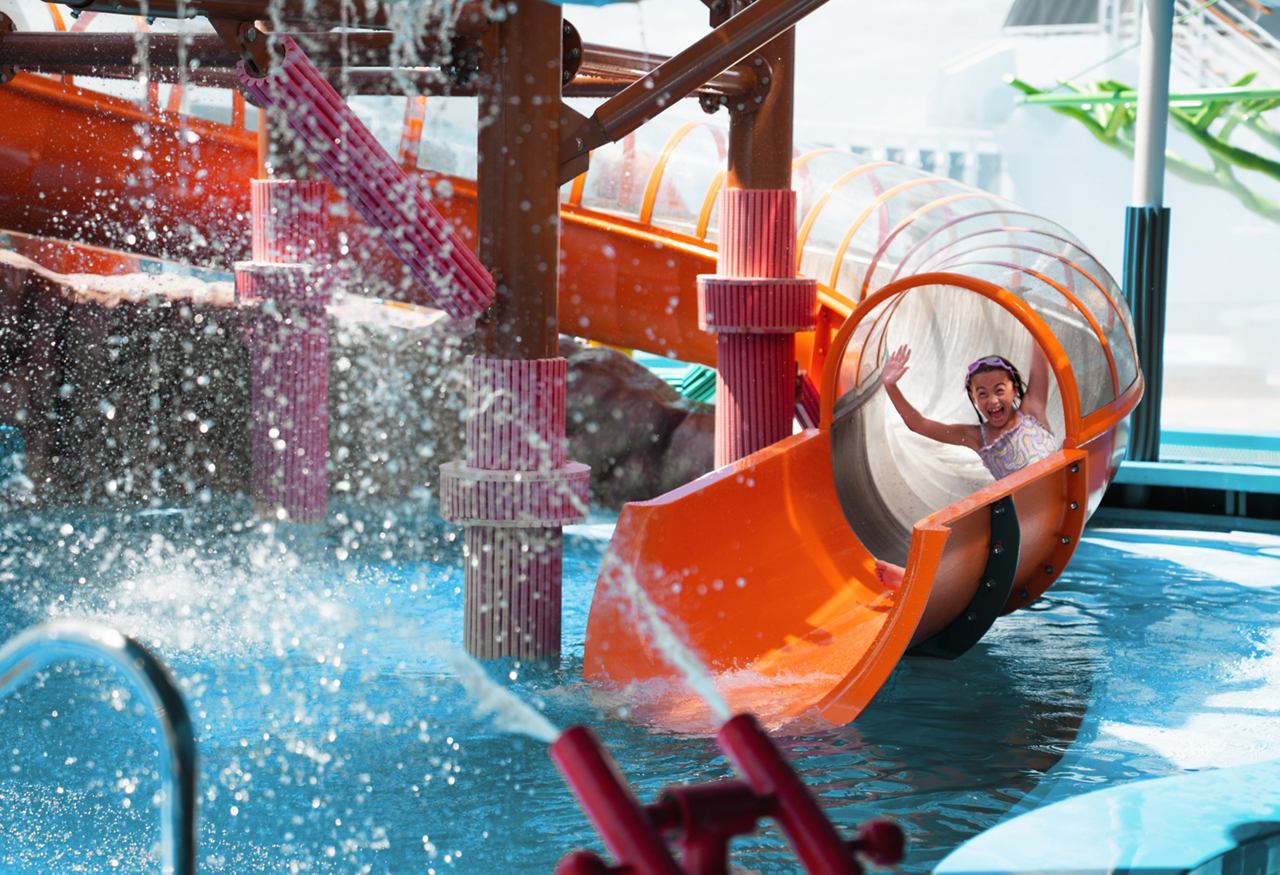 Happy child swimming in pool wearing swim cap and goggles | MSC Cruises