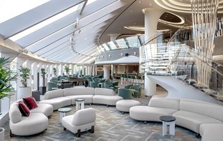 A spacious lounge area featuring modern seating and large windows for natural light | MSC Cruises