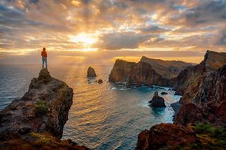 A breathtaking sunset over rugged cliffs and tranquil waters, inviting exploration and adventure | MSC Cruises