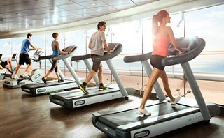 Menschen trainieren auf Laufbändern in einem hellen Fitnessbereich mit großen Fenstern, der Gesundheit und Wohlbefinden fördert | MSC Cruises