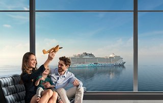 Ein Paar genießt ein Getränk und blickt durch große Fenster auf eine atemberaubende Meersicht | MSC Cruises