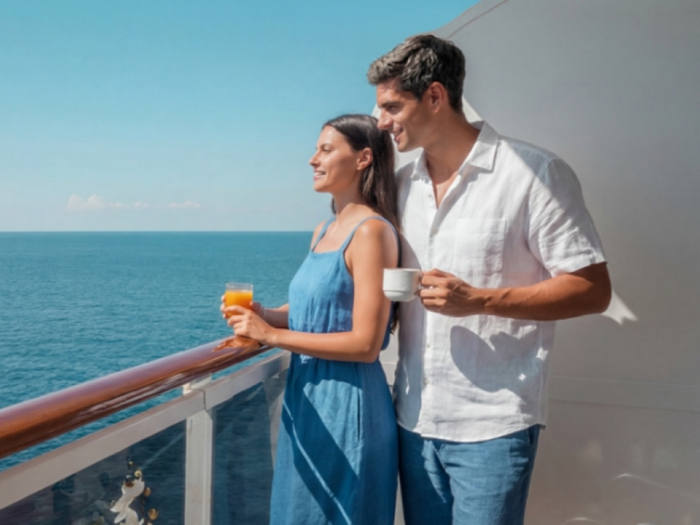 A couple enjoys the expansive ocean view from the balcony of a cruise ship | MSC Cruises