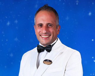 Officer in white uniform with a confident pose and name badge | MSC Cruises