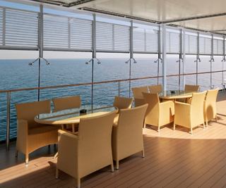 Bright dining area with tables and chairs overlooking the sea | MSC Cruises