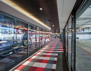 A spacious corridor leading to a vibrant entertainment area with large windows and colourful flooring | MSC Cruises
