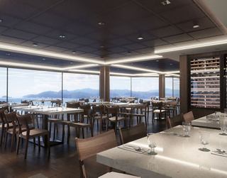 Un espacioso comedor con grandes ventanas que ofrece vistas y elegantes arreglos de asientos para los huéspedes | MSC Cruceros