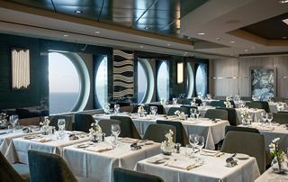 Elegante Restaurantumgebung mit schön gedeckten Tischen und atemberaubenden Fenstern | MSC Cruises